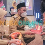 Bupati Gresik, Fandi Akhmad Yani, saat memberi makanan bergizi kepada balita usai membuka dialog kebangsaan. Foto: SYUHUD/BANGSAONLINE