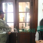 Petugas dari Satpol PP dan Polres Malang Kota sedang melakukan penjagaan di pintu masuk ruang kerja Wali  Kota Malang HM. Anton. foto: IWAN IRAWAN/ BANGSAONLINE