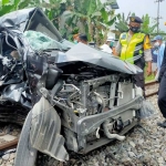 Kondisi mobil usai diseruduk kereta api.