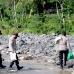 Kapolres Lumajang saat menuju lokasi pembagian sembako yang harus menyeberangi sungai.