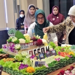 Gubernur Jawa Timur Khofifah Indar Parawansa memotong tumpeng saat meresmikan kantor baru Dinas Energi Sumber Daya dan Mineral (ESDM) Provinsi Jawa Timur, Selasa (14/2/2023). Foto: BANGSAONLINE