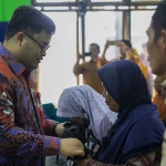 Bupati Kediri, Hanindhito Himawan Pramana, saat menyerahkan bantuan kepada salah seorang warga. Foto: Ist