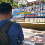 Spanduk penerapan protokol kesehatan yang terpasang di pagar SMAN 1. 