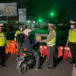 Polantas Sidoarjo menyerahkan sembako kepada pengendara motor. (foto: ist)