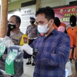 Kapolresta Banyuwangi Kombes Pol Arman Asmara Syarifudin sedang menunjukkan barang bukti para tersangka.