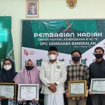 Syafiuddin saat menyerahkan hadiah Lomba Gebyar Festival Kemerdekaan Gemasaba Bangkalan di Aula Graha Kebangkitan Bangsa, Senin (23/8/2021). (foto: ist)