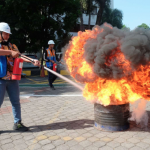 Seorang karyawan pelindo mengikuti lomba memadamkan api menggunakan alat pemadam api ringan (APAR). Foto: Ist