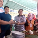 Bupati Fadeli memberi potongan tumpeng kepada Ketua PWI Lamongan, Bachtiar Febrianto.