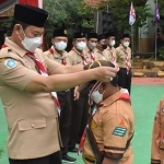 Bupati Lamongan, Yuhronur Efendi, saat mengalungkan medali pada pramuka yang dilantik jadi Siaga Garuda.