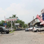 Kondisi ruko di kompleks Pandaan yang kurang terawat, jalan berlubang, dan bangunan tampak kusam.