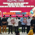 Kedua paslon Pilkada Sidoarjo 2024 didampingi komisioner KPU Sidoarjo menunjukkan nomor urut hasil pengundian, Senin (23/9/2024). Foto: Mustain/BANGSAONLINE