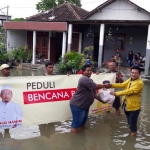 Caleg Golkar Wongso Negoro saat menyerahkan sembako kepada korban banjir di Desa Gadingwatu, Menganti. foto: SYUHUD/ BANGSAONLINE