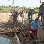 TNI bersama warga gotong royong membersihkan sampah. (foto: ist)