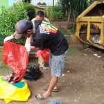 Petugas di sekitar TPS Junok, Bangkalan, saat membersihkan sampah medis.