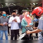 M. Syuhud Almanfaluty, Gus Yani, Bu Min, Kapolres, dan Kasdim saat bagi-bagi masker dan hand sanitizer kepada pengguna jalan dalam rangka HPN KWG 2021. foto: SYUHUD/ BANGSAONLINE