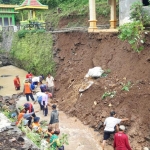 Kades Kalipang Antonius Supratiknya saat memimpin kerja bakti warga memperbaiki plengsengan yang longsor. foto: MUJI HARJITA/ BANGSAONLINE