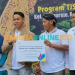 Manajer UPT PLN Madiun, Nur Fajar Fardiansyah Umar, saat menyerahkan bantuan secara simbolis kepada Ketua Pokdarwis Sumber Banteng, Sudarsono, yang disaksikan langsung oleh Wali Kota Kediri, Abdullah Abu Bakar. Foto: MUJI HARJITA/ BANGSAONLINE