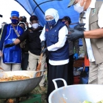 Gubernur Jawa Timur Khofifah Indar Parawansa ikut mengaduk makanan saat mengunjungi lokasi penanganan Klaster Covid-19 di Pondok Pesantren Darussalam Blokagung, Kecamatan Tegalsari, Banyuwangi pada Rabu (2/9). foto: ist/ bangsaonline.com