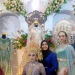 Santi (baju biru) pemilik Trisanti Wedding & Boutique berpose dengan model saat acara Ethereal Wedding Exhibition di Aston Madiun Hotel, Jumat (26/8/2022). Foto: HENDRO SUHARTONO/ BANGSAONLINE