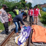 Petugas dibantu warga mengevakuasi jasad korban. 