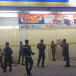 Petugas Dinas Satpol PP Pemkab Gresik saat menyegel Indomaret di Desa Kedanyang. foto: SYUHUD/ BANGSAONLINE