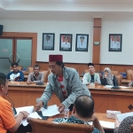 Salah satu KPM BPNT memberikan bukti dugaan penyelewengan bansos kepada kepala PT Pos Sampang saat audiensi berlangsung. Foto: MUTAMMIM/ BANGSAONLINE