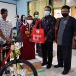 Plt Kepala Dinsos Kota Kediri, Ferry Djatmiko, saat menyerahkan bantuan kepada salah satu penyandang disabilitas. Foto: Ist