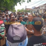 Camat Tikung, Arifin, saat menemui massa aksi. Foto: NUR QOMAR HADI/BANGSAONLINE