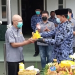 Wali Kota Maidi menyerahkan potongan tumpeng kepada Ketua PWI Kota Madiun Siswo Widodo. 