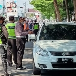 Perugas gabungan saat menghentikan sebuah mobil bernomor polisi L yang masuk ke Kota Kediri. foto: MUJI HARJITA/ BANGSAONLINE