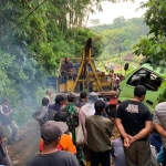 Mobil derek diterjunkan untuk mengevakuasi truk yang terperosok ke jurang.