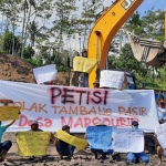 Alat berat yang didemo warga. (foto: MUJI HARJITA/ BANGSAONLINE)