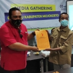 Ketua PWI Mojokerto Diak Eko Purwoto menunjukkan berkas MoU kerja sama Bawaslu dan PWI Mojokerto. foto: YUDI EP/ BANGSAONLINE