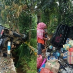 Kondisi pick up yang terbalik masuk parit berikut barang bawaan yang porak-poranda. 
