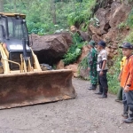 Anggota TNI-Polri dan pemdes saat mengevakuasi tanah longsor dan bongkahan batu.