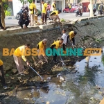 Anggota Polres Jombang bersama elemen masyarakat saat membersihkan sungai. Foto: AAN AMRULLOH/BANGSAONLINE