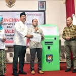 Wali Kota Pasuruan Saifullah Yusuf (pakai peci) saat menyerahkan kartu keluarga (KK) yang dicetak dari anjungan dukcapil mandiri usai launching.