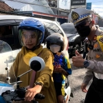 Petugas dari Satlantas Polres Tulungagung saat membagikan cokelat untuk pengendara.