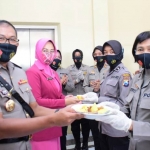 Kapolresta Sidoarjo Kombes Pol. Sumardji menyerahkan potongan tumpeng kepada anggota polwan.