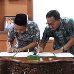 Bupati Gresik Fandi Akhmad Yani (kiri) dan Ketua PA Gresik Ahmad Zainal Fanani saat teken kerja sama. Foto: Ist.