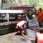 Petugas pemadam kebakaran saat memadamkan api mobil jenis L300 yang terbakar.