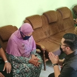 Bupati Kediri Hanindhito Himawan Pramana (bersimpuh) saat mengunjungi rumah orang tua Serda Lis Edi Wibowo di Desa Ngadiluwih. (foto: MUJI HARJITA/BANGSAONLINE)