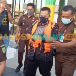 Kades Roomo, Rusdianto, dikawal Kasi Intel Kejari Gresik, Deni Nirwansyah, menuju mobil tahanan. Foto: SYUHUD/BANGSAONLINE