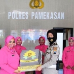 Ketua Bhayangkari Polres Pamekasan Ny. Poppy Apip Ginanjar memberikan bingkisan kepada salah satu perwakilan Polwan Polres Pamekasan, Ipda Sri Indarwati S.H.