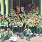 Para siswa MI Manbail Futuh foto bersama para jurnalis yang tergabung dalam RPS di Balai Wartawan.