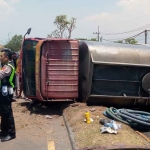 Petugas saat mengatur lalu lintas akibat truk tangki air yang terguling di Sidoarjo.