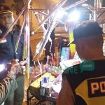 Petugas saat merazia salah satu lapak penjual kembang api, untuk mengecek apakah ada petasan yang memiliki daya ledak tinggi. foto: GUNAWAN/ BANGSAONLINE