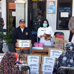 Erly Maya Muryarti, Lurah Pojok, Kecamatan Mojoroto bersama Relawan Gusdurian saat akan membagikan sembako kepada warga. (foto: MUJI/BANGSAONLINE).