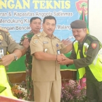 Camat Donomulyo Mahendra Irawan memberikan rompi kepada Linmas.