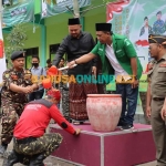 Bupati Gresik, Fandi Akhmad Yani, saat menyiramkan air dari gayung ke kepala salah satu Banser saat penutupan Susbalan Satkorwil Jawa Timur ke-38. Foto: SYUHUD/BANGSAONLINE